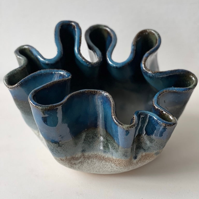Blue ceramic bowl with wavy design on a white background