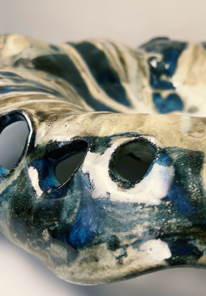 Ceramic vase with blue and white abstract design on a plain background